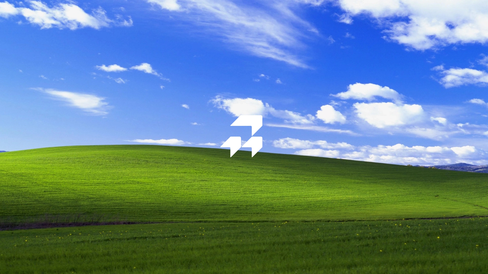 The RightNow mark over a green hill and a blue sky.